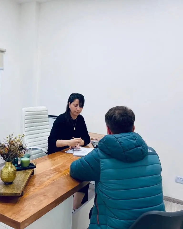 Una profesional de LegalMente revisa documentación con un cliente en su escritorio