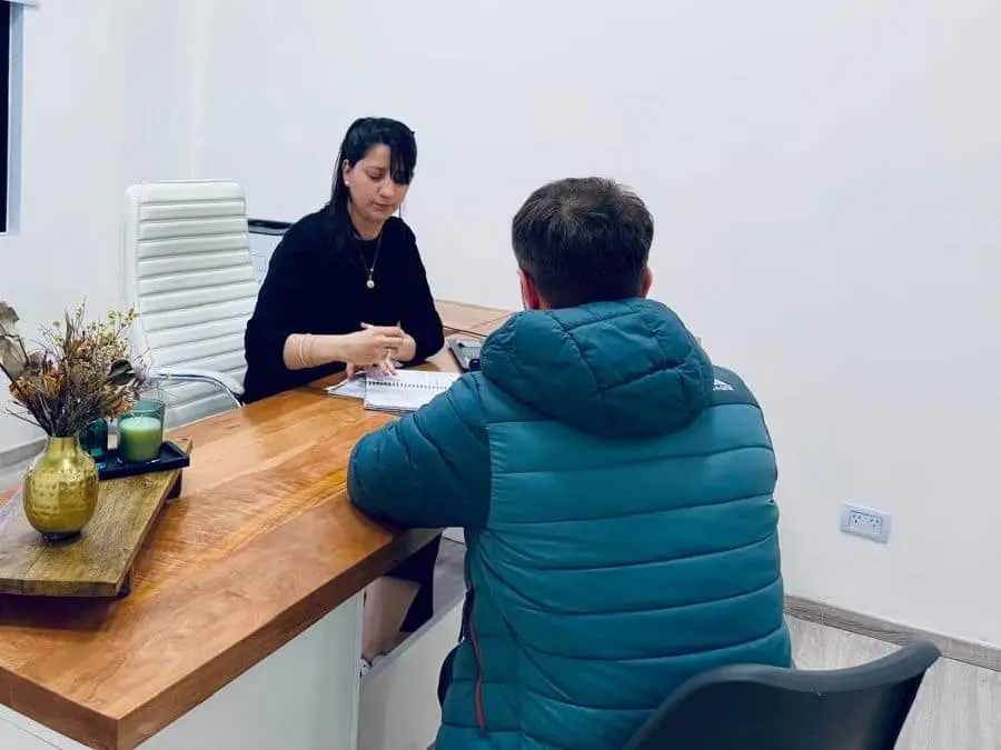 Una profesional de LegalMente revisa documentación con un cliente en su escritorio