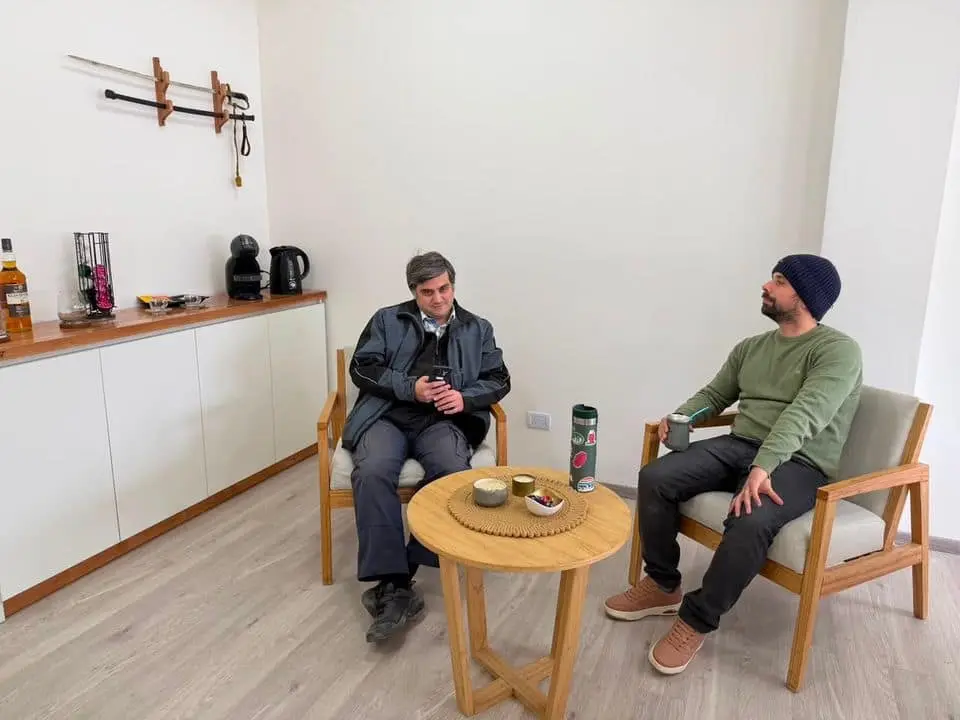 Dos personas esperan con un café en los sillones de la sala de espera de LegalMente